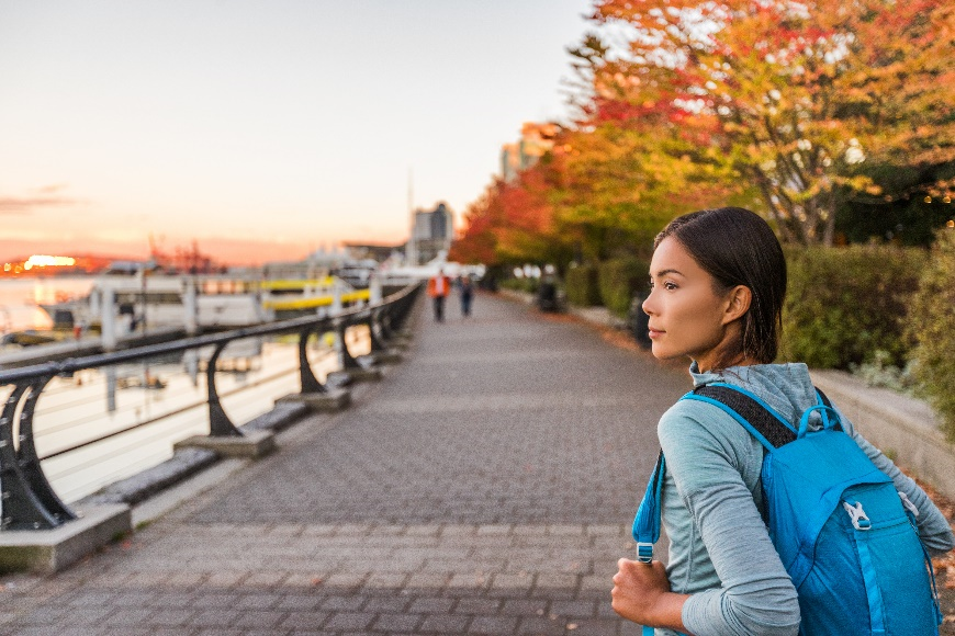 Girl with backpack standing on brick walkway